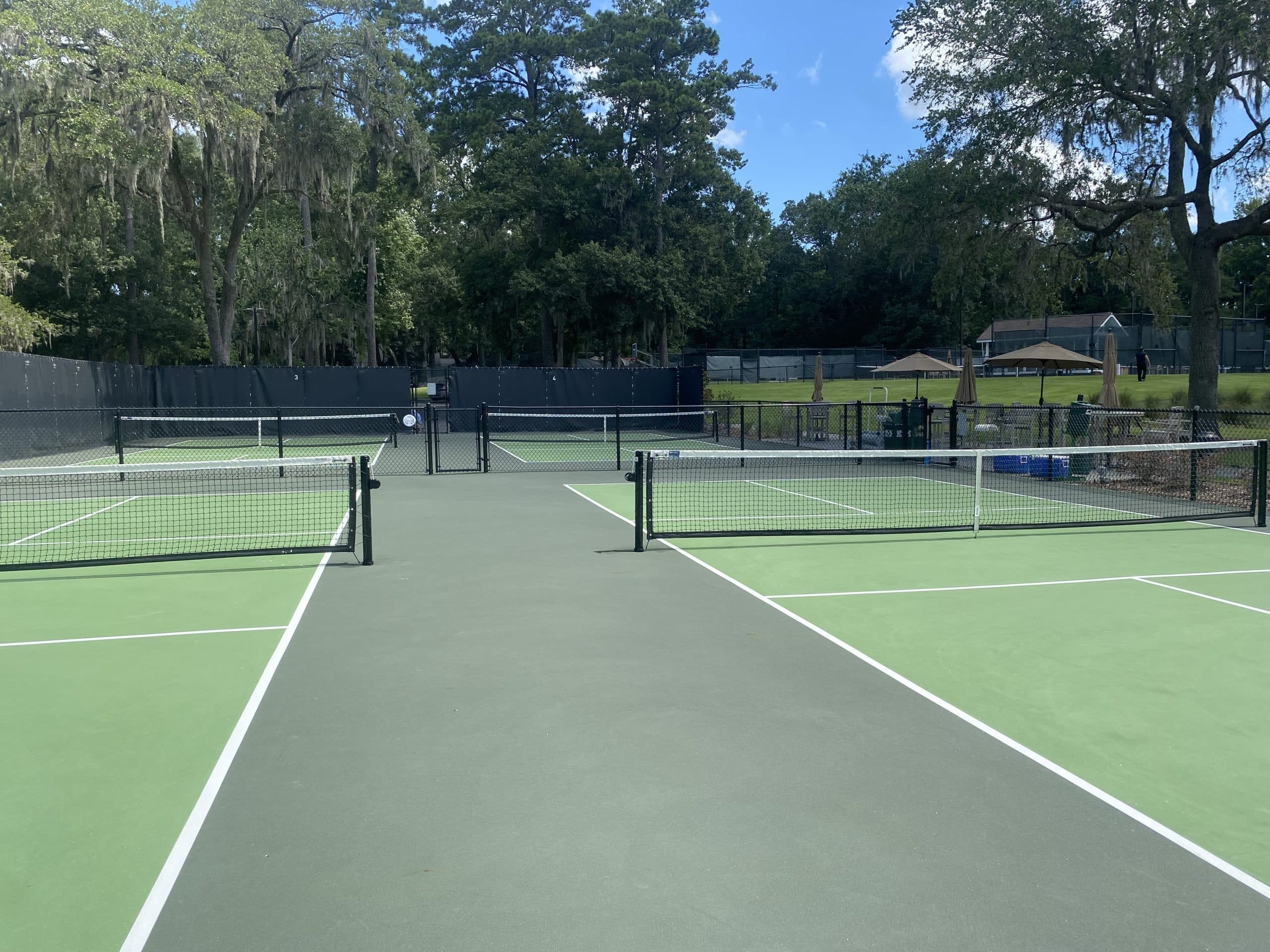 the courts from the baseline, nets up under the oaks