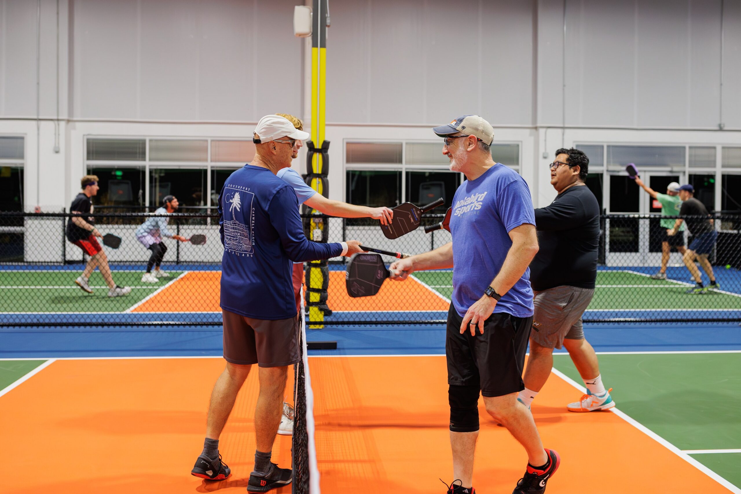 a point at the net on the indoor courts, orange and green surface