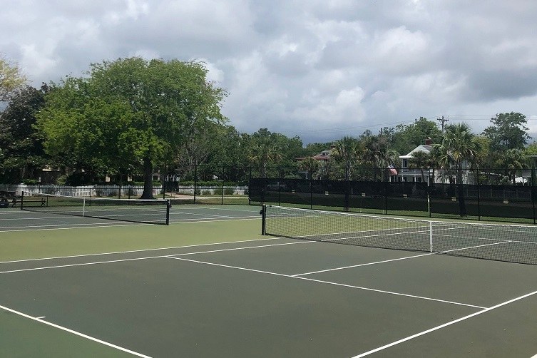 the town courts under a wide sky, nets up and lines fresh