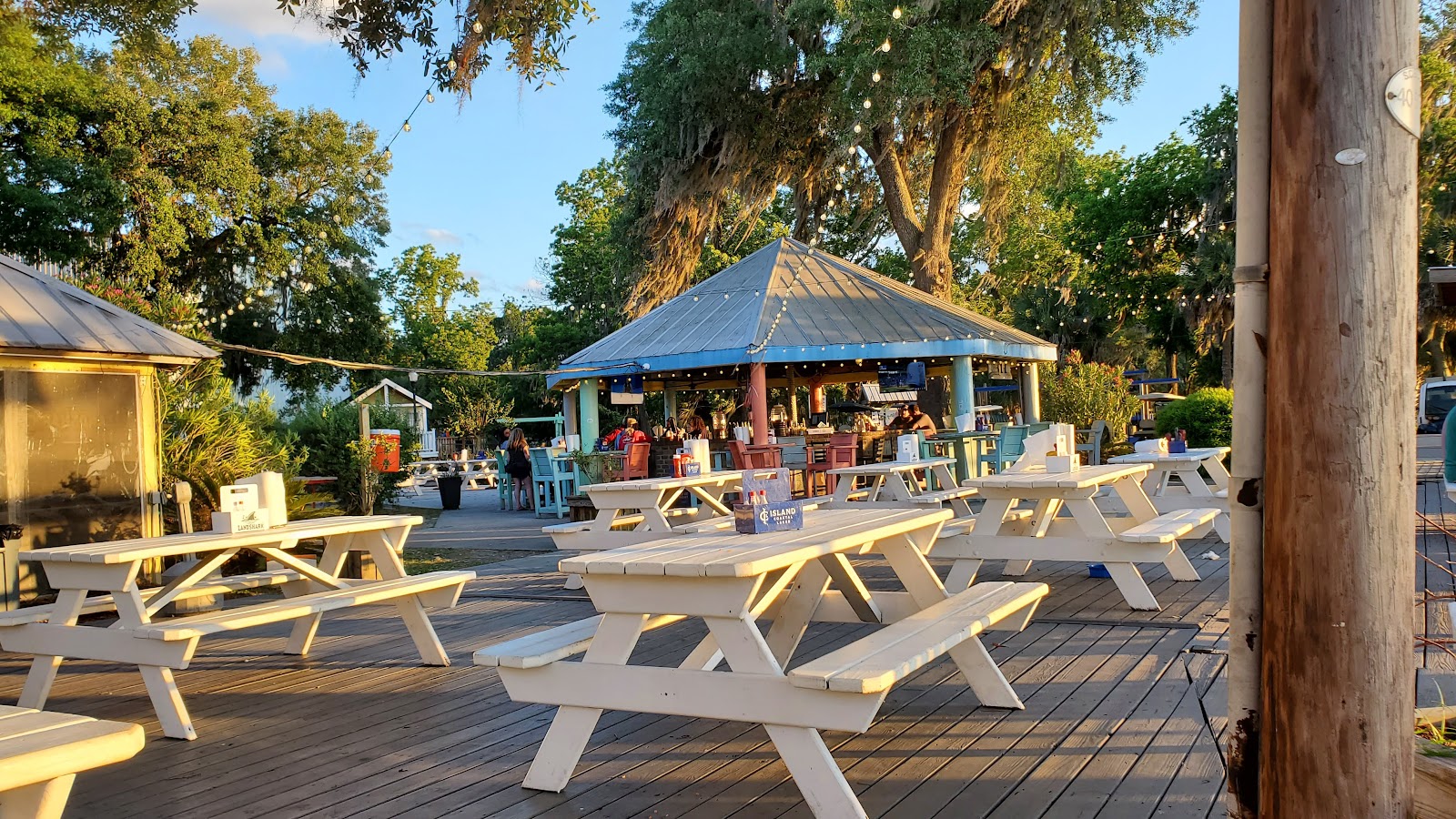 Picnic tables and a tin-roofed pavilion strung with lights under live oaks at the Old Daufuskie Crab Company