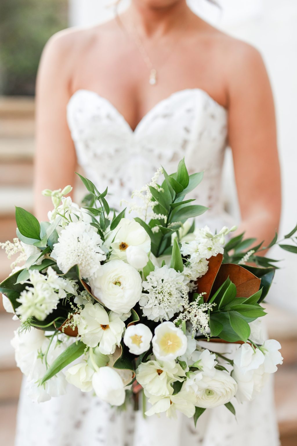 A white bridal bouquet of ranunculus and greenery