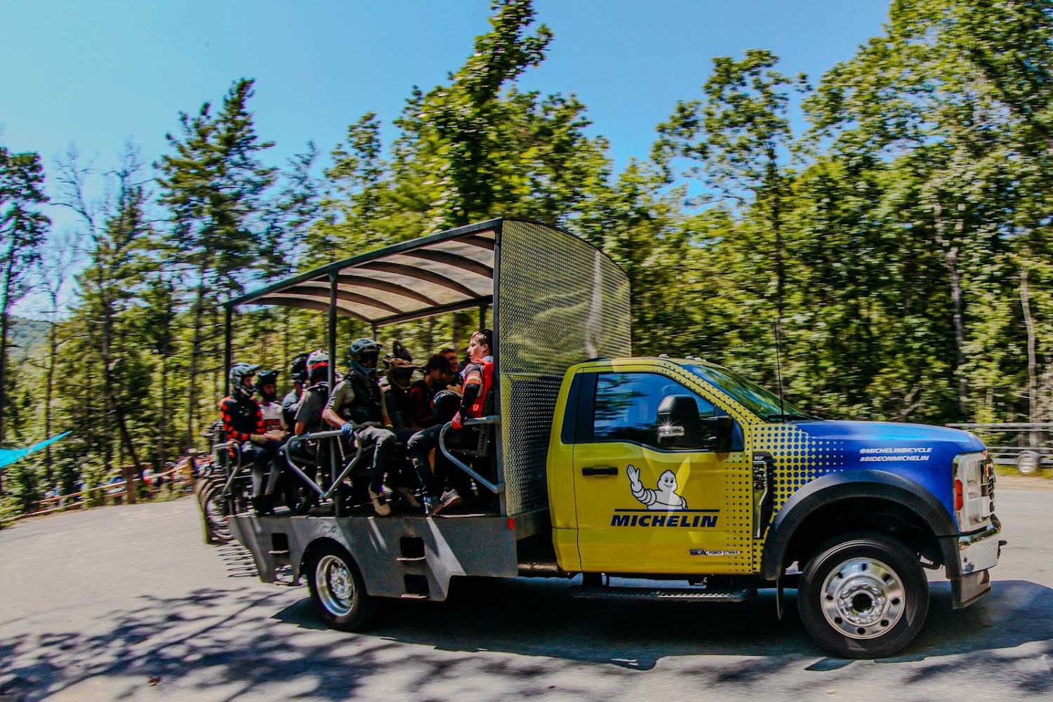 An open-sided shuttle truck carries a dozen riders and their bikes up the mountain at Ride Rock Creek.