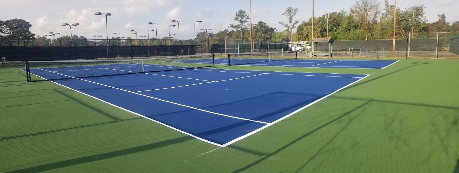 the resurfaced courts, blue on green, looking down the baseline